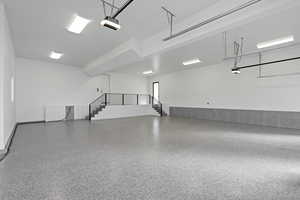 Garage featuring a garage door opener and baseboards