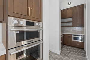 Kitchen featuring stainless steel appliances, light countertops, and tasteful backsplash