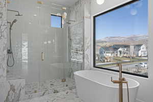 Full bath with a stall shower, a soaking tub, a mountain view, and a residential view