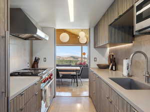 Kitchen featuring decorative backsplash, appliances with stainless steel finishes, extractor fan, lofted ceiling, and a mountain view