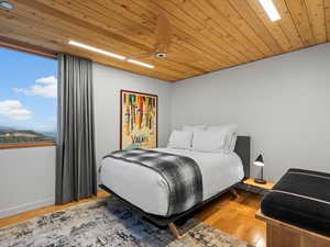 Bedroom with wood finished floors and wood ceiling