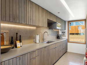 Kitchen with light countertops, backsplash, and modern cabinets