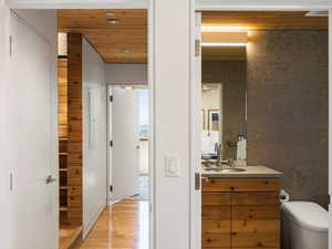 Bathroom with vanity, wood finished floors, and tile walls