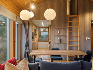 Living area with a towering ceiling, wood walls, and wood ceiling