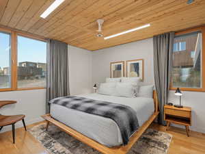 Bedroom with wooden ceiling, wood finished floors, and a ceiling fan