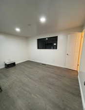 Below grade area with dark wood-style flooring and recessed lighting