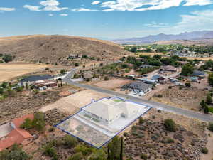 Aerial view of residential area with property parcel outlined and a mountain backdrop