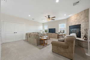Main Family Room area with a fireplace, light colored carpet, recessed lighting, ceiling fan, floor to ceiling wood burning stone fireplace and built in cabinet.  Double doors are to the 5th bedroom / exercise or game room.