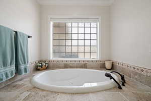 Full master suite bath with a jetted garden tub, acrylic glass block window with an electric shade.