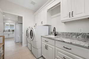 ADU full laundry room with sink, soft-close white cabinetry, recessed lighting and built-in ironing board