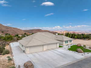 View of front of home featuring stone siding, a mountain view, an attached garage, stucco siding, and driveway, Low E Windows, artificial turf