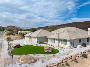 View of front of home featuring stone siding, a mountain view, stucco siding, concrete driveway, and a chimney, Low E Windows