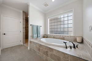 Full master suite bath featuring a jetted garden tub, walk in shower, crown molding, beautiful tile, acrylic glass block window with electric shade and recessed lighting