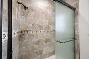 ADU bathroom with a tile shower and glass sliding shower door