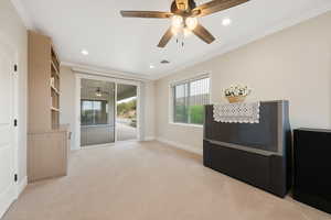 5th Bedroom (or exercise / game room) featuring built-in bookcase, ornamental molding, access to rear patio, light carpet, recessed lighting, and a ceiling fan.
