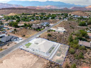 Aerial view of residential area with property parcel outlined and a mountain backdrop