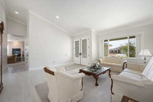 Main formal living room  & entry featuring a stone fireplace in family room, ornamental molding, high vaulted ceiling, and recessed lighting, 3-tone paint, front entry doors