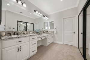 Full master suite bathroom with vanity, ornamental molding, carpet, and recessed lighting plus sliding mirrored ward-robe doors.