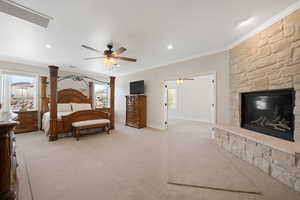 Spacious Master Suite with ornamental molding, floor to ceiling stone fireplace with hearth, ceiling fans in attached office, light colored carpet, recessed lighting.