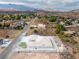 Aerial view of residential area featuring property parcel outlined and a mountainous background
