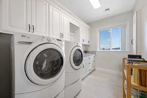 ADU full laundry room with sink featuring white soft-close cabinetry and built-in ironing board.