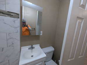 Half bathroom featuring vanity and toilet