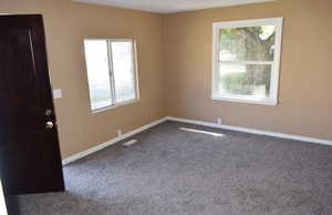 Unfurnished room featuring carpet and baseboards