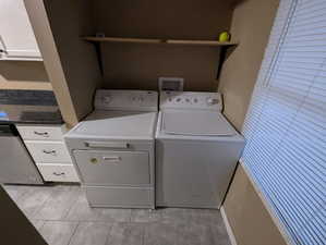 Laundry area featuring washing machine and dryer and cabinet space