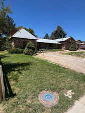 View of green lawn with a garage and driveway
