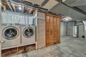 Unfinished below grade area featuring gas water heater and washer and clothes dryer