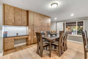 Dining area with light wood finished floors and recessed lighting