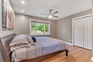 Bedroom featuring light wood finished floors, a closet, recessed lighting, and ceiling fan