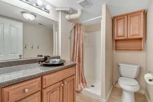 Bathroom featuring tile patterned floors, vanity, and a shower stall