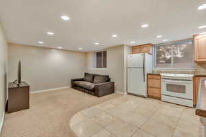 Unfurnished living room featuring recessed lighting, light colored carpet, and light tile patterned floors