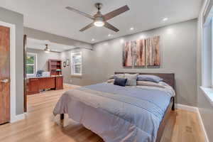 Bedroom with a desk, light wood-style flooring, recessed lighting, and a ceiling fan