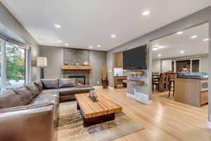 Living area featuring recessed lighting, light wood-style floors, and a brick fireplace