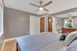 Bedroom featuring light wood-style floors, ceiling fan, and a closet