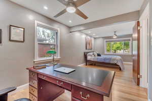 Bedroom with multiple windows, light wood finished floors, recessed lighting, a desk, and a ceiling fan