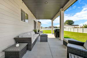 Fenced backyard featuring an outdoor living space with a fire pit, a patio area, and grilling area