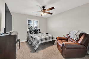 Carpeted bedroom with baseboards and a ceiling fan