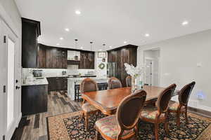 Dining room with dark wood-style floors and recessed lighting