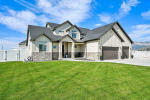 View of front of home featuring board and batten siding, a gate, a shingled roof, and concrete driveway