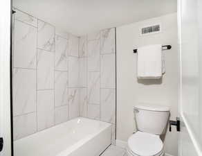 Bathroom featuring a textured ceiling and shower / washtub combination