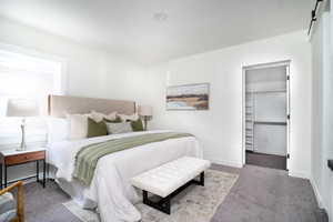 Bedroom with carpet and a walk in closet