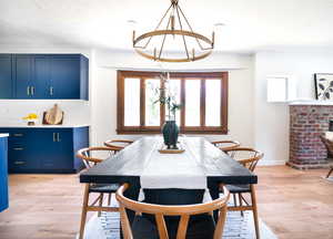 Dining room with light wood finished floors, a textured ceiling, and a chandelier