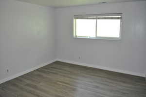 Spare room with dark wood finished floors and baseboards
