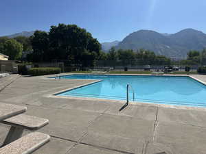 Community pool with a patio and a mountain view