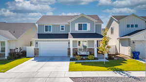 Craftsman-style home featuring a porch, roof with shingles, a front lawn, and driveway