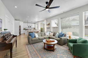 Living area featuring ceiling fan, light wood-style flooring, a textured ceiling, and recessed lighting