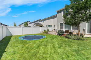 Fenced backyard featuring a trampoline and a residential view